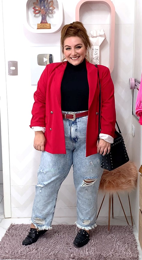 Mujer plus size vistiendo un pantalon mom fit con saco rojo y bolsa negra. 